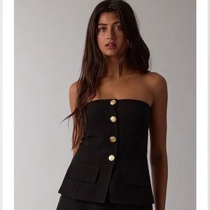 black spaghetti strap crop top with gold-toned buttons and pocket flaps.